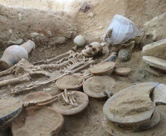 View of the Etruscan burial chamber. In the foreground bowls and animal remains and towards the back the deceased.           Source: Roland Haurillon, Inrap