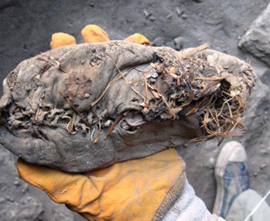 5500-year-old shoe in hand of researcher 