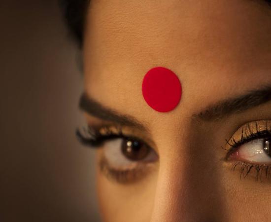 Close-up of a woman's eyes and red bindi.