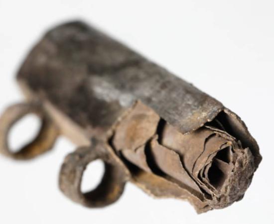 Close-up photograph of rolled up silver foil scroll inside silver amulet from third century BC, found in Frankfurt, Germany.