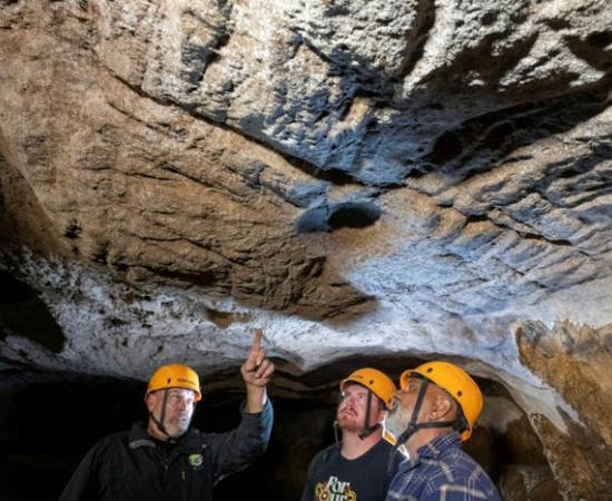 Mal and Dylan Siely examine finger grooves at Waribruk with GunaiKurnai Elder Uncle Russell Mullett