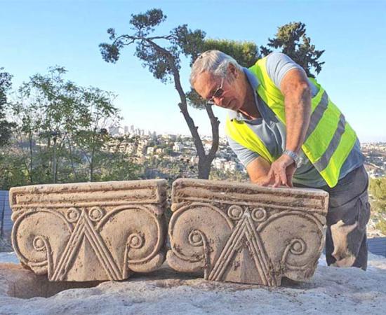 Director of the Jerusalem Promenade excavation Yaakov Billig with the unearthed capitals that likely were part of a First Temple Period palace.            Source: Yoli Shwartz / Israel Antiquities Authority
