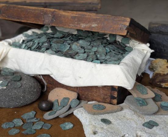 Some of the coins and treasure from the wrecksite, in a modern treasure chest.