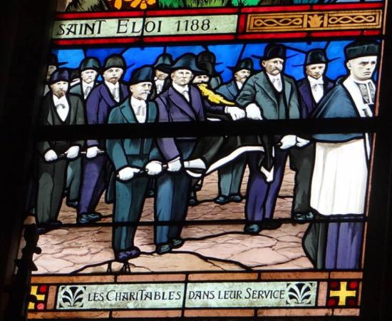 Stained glass window showing the French brotherhood ‘Confrérie des Charitables de Saint-Éloi’,  in Saint-Vaast Church, Béthune         Source: CC BY-SA 3.0