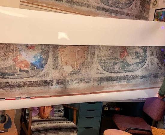 Home owner Luke Budworth posing with the frescoes in York and the life-size reproduction produced by Historic England. Source: Luke Budworth