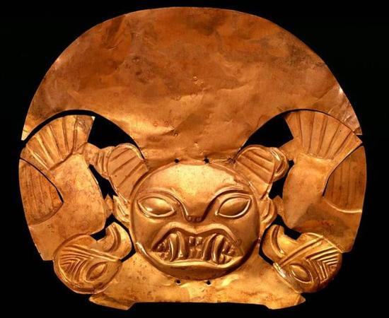 Gold Mochica Headdress (1 – 700 AD) representing a feline deity with fangs and condor ornaments. 