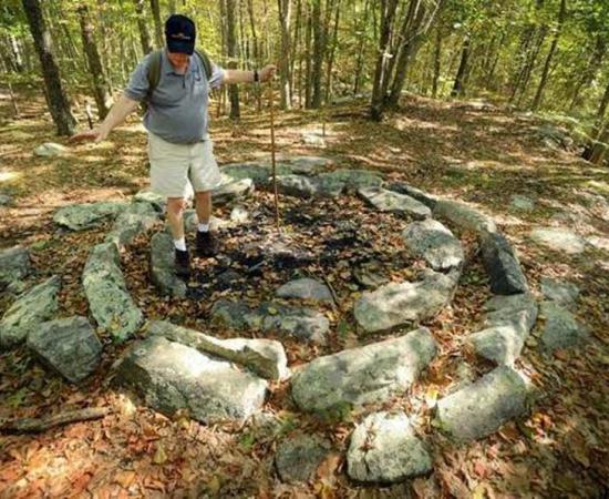 Al Brown of the Denison Pequotsepos Nature Center talks about the stone ring that makes up one of the different sites in the Gungywamp property in the woods of Groton, Connecticut. Photo source: Tim Cook / The Day