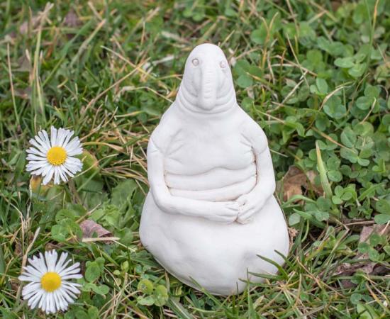 Clay homunculus model placed on a lawn