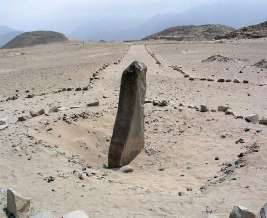 The monolith called Huanca with pyramids in the background in Caral-Supe 