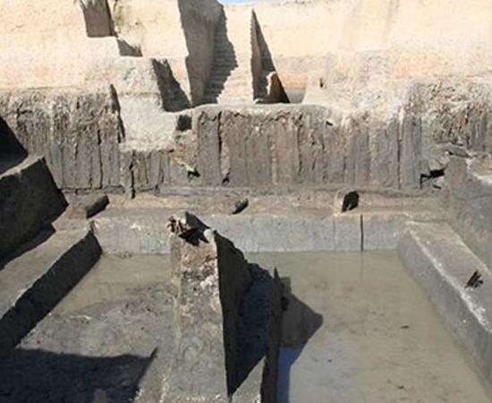 A Liangzhu period structure of the Meirendi bank with wooden planks still standing upright.