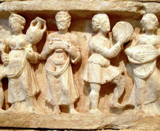 Hellenistic culture in the Indian subcontinent: Greek clothes, amphoras, win,e and music. Detail from Chakhil-i-Ghoundi Stupa, Hadda, Gandhara, 1st century AD. 