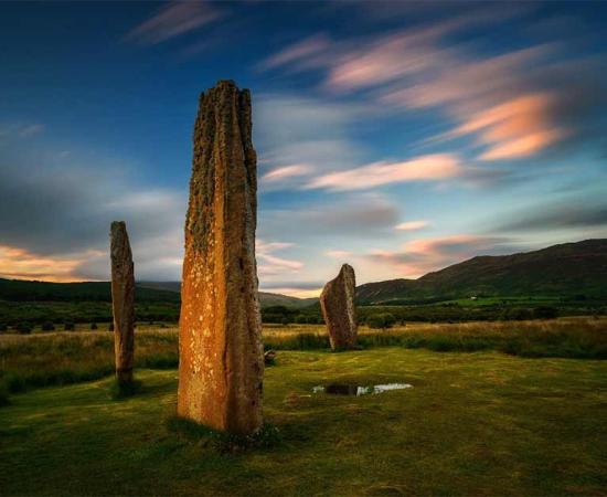 Machrie Moor on the Isle of Arran at sunset with two magnificent standing stones in the foreground. Source: swen_stroop / Adobe Stock