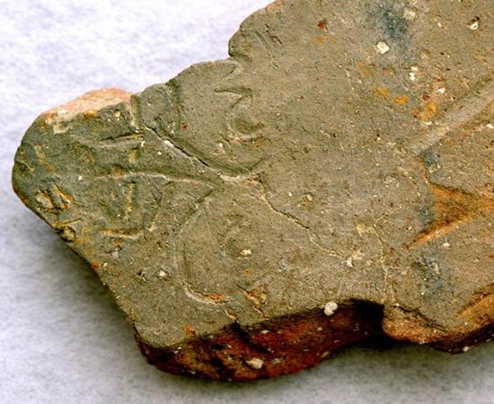 A tile inscribed with the character for “flight” goes on display in a Japanese museum. The tile is from the site of Japan's first Buddhist temple (Yoshinori Toyomane)