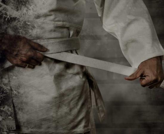 Jujutsu practitioner tightening their belt. Source: Soloviova Liudmyla / Adobe Stock