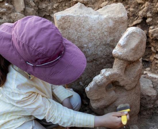 : An archaeologist cleans the human-on-leopard sculpture in situ at Karahantepe