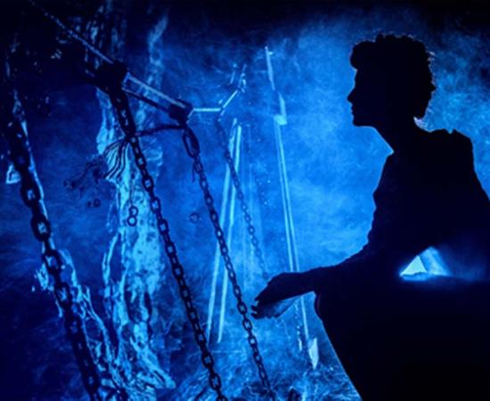 Silhouette of a mysterious witch inside a cave 