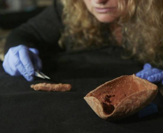 Dr. Naama Sukenik examining the ancient lamp wick