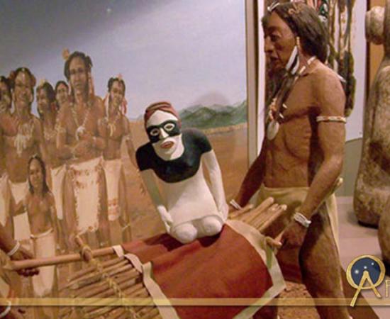 A diorama at the Etowah Mounds showing two stone effigies being ritually buried, next to the actual statues, seen from the rear