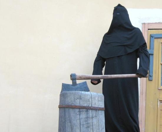 A medieval executioner with executiners ax and block.
