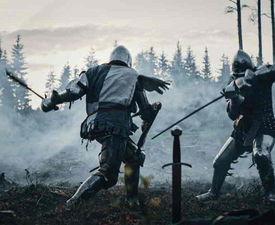 Reenactment of two Armored Medieval Knights Fighting with Swords. Source: Gorodenkoff/Adobe Stock