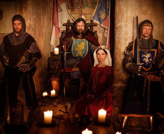 Medieval Queen, her King and knights in castle. 