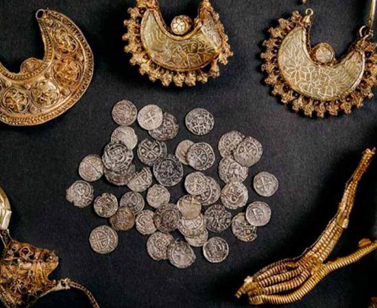 The complete Hoogwoud hoard: four gold pendants, two pieces of gold leaf and 39 silver medals. Source: © Archeology West-Friesland/Fleur Schinning