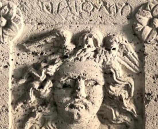 Burial urn with Medusa relief and Etruscan inscription.