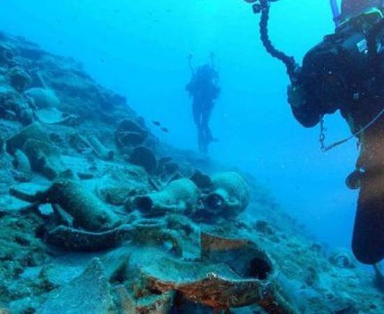 Underwater archaeologists examine objects found around the wreck. 