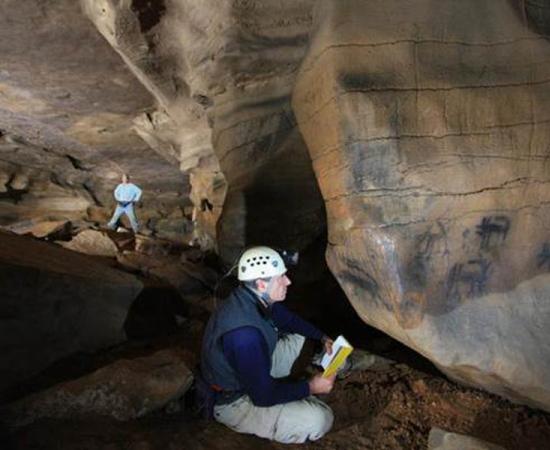 Jan Simek, professor of anthropology, next to Mississippian Period cave drawings.		Source: University of Tennessee Knoxville