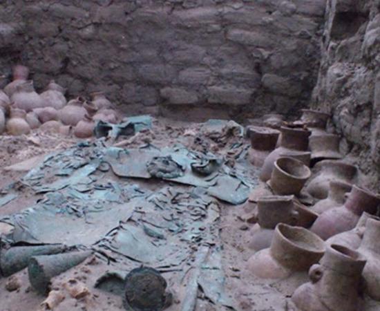 A rich Moche grave with elaborate copper artifacts and several ceramic vessels. 