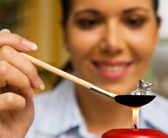 Woman practicing molybdomancy for New Year’s Eve. (Source: Gina Sanders / Adobe Stock