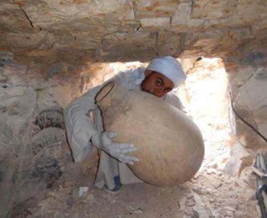 A worker on the Middle Kingdom Theban Project takes out an embalming jar he had just discovered among a cache of other embalming materials of the Vizier Ipi, who lived more than 4,000 years ago. (Photo courtesy of the Spanish Mission)