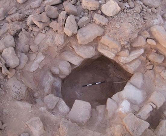 Stones cover the body of the first remains of a woman found at copper mines in Timna, Israel - and she was pregnant.