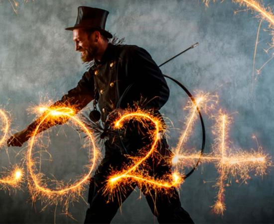 Chimney sweep in work clothes writes the year 2024 with sparklers. Source: Werner/Adobe Stock