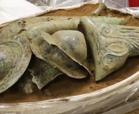 The Iron Age hoard from Norfolk, showing shield bosses in the center with the boar's head visible on the right, and the carnyx at the back