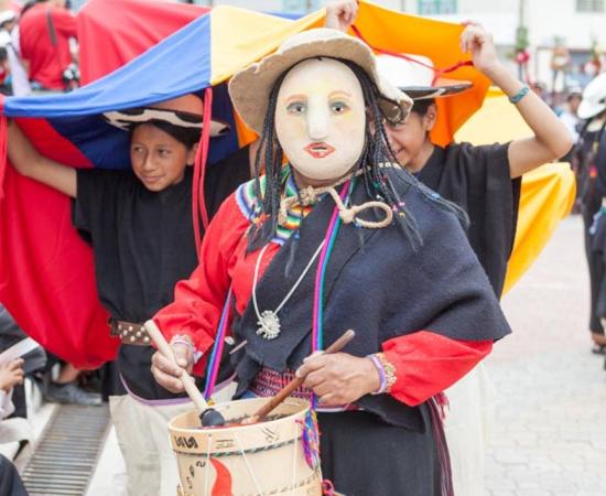 A masked woman leads a procession as part of the ceremony of Pawkar Raymi. 