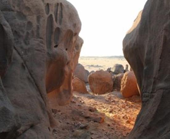 Man-made holes visible amongst the natural erosion features of the granite rock in Sudan 