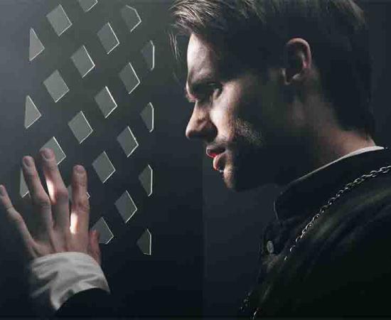 A young priest listens to confession. 