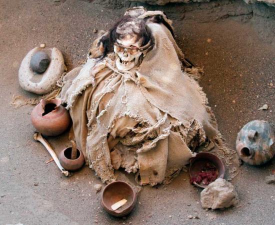 A mummified individual discovered in Chauchilla, Nazca, Peru, with traditional pre-Columbian burial dress and goods. One of the recently discovered mummies was holding a cross, supporting an estimated date in the colonial period. Source: Gerardo Daniel / Adobe Stock