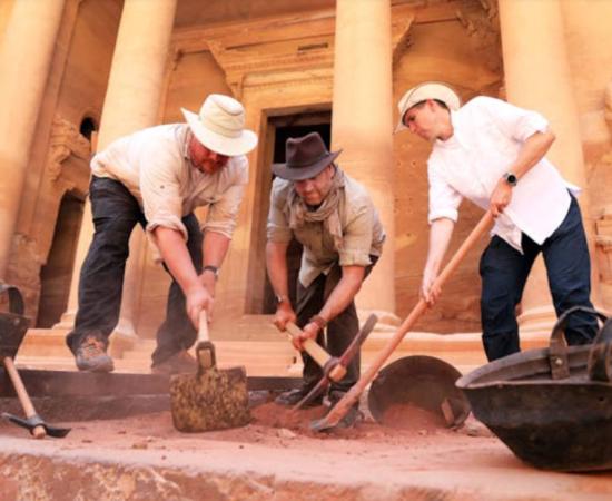 Josh Gates and Pearce Paul Creasman with archaeologist Matthew Vincent, in front of the Treasury at Petra