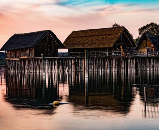 Colorful sunset at Lake Dwellings of the Stone and Bronze Age at Pfahlbaumuseum in Unteruhldingen on Lake Constance, Baden-Wurttemberg.