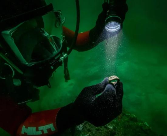 The Lighthouse of Alexandria ring at the time it was found held by underwater archaeologist.
