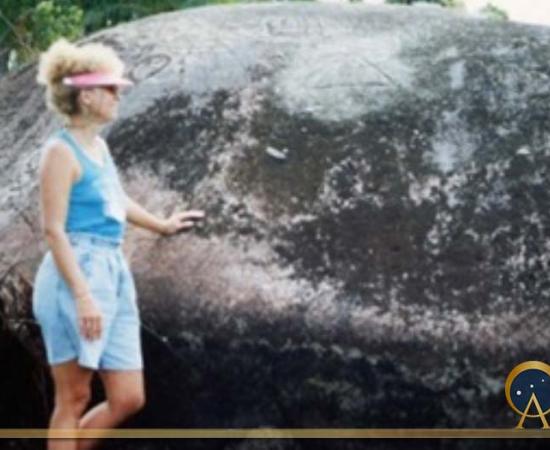 Phallic megalith covered with glyphs and author in the Pohnpaid meadow (Image © 1992 Carole Nervig)