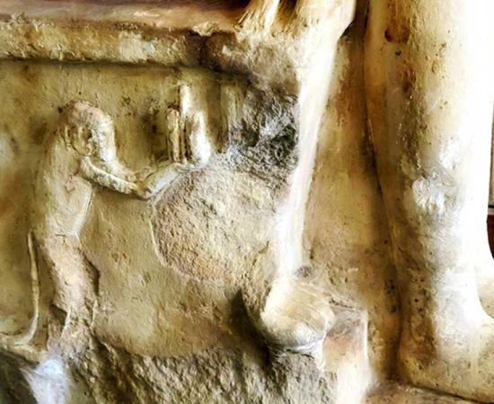 Detail from the side of a seat of a group sculpture shows a baboon holding a cosmetic pot or kohl eyeliner; design by Anand Balaji 