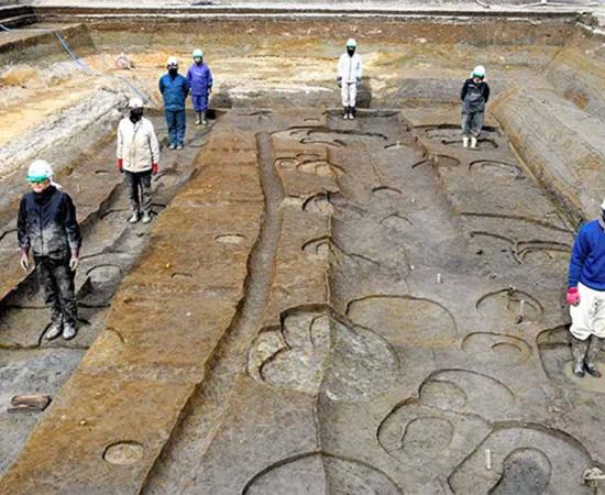Researchers stand where massive timber pillars once stood to give a perspective on the size of the site of the home of Prince Toneri in Nara.            Source: Nara City Board of Education/Asahi