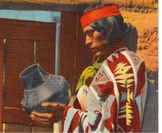 This postcard shows a Pueblo Indian man with San Ildefonso Black Pottery. The postcard was published between 1930 and 1945. 
