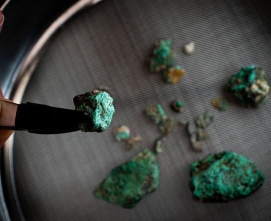 Malachite fragments, a mineral rich in copper, recovered during the excavation works at Cova 338.