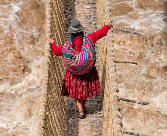 Inca woman crossing the Q'eswachaka rope bridge. Source: Danita Delimont / Adobe Stock.