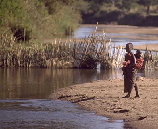 Child standing on the edge of a river