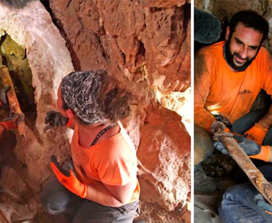 Archaeologists Oriya Amichay and Hagay Hamer removing one of the Roman swords from the crevice where they were hidden. Source: Amir Ganor/Israel Antiquities Authority